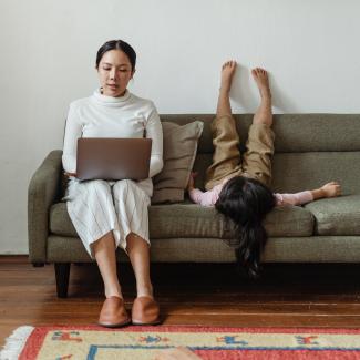 Woman sits on couch to work from home